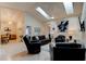 Open living room with a vaulted ceiling, neutral paint, tile flooring, and skylights for abundant natural light at 1918 Whisperwood Way # 10, Port Orange, FL 32128