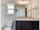 Bathroom with granite countertop, dark wood cabinets and view into an adjacent room at 208 Lagoon Mist Ct, Oak Hill, FL 32759