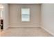 Neutral bedroom featuring a window allowing for natural light and soft, neutral carpeting at 208 Lagoon Mist Ct, Oak Hill, FL 32759