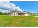 Charming brick home featuring a well-kept lawn, attached garage, and solar panels at 208 Lagoon Mist Ct, Oak Hill, FL 32759