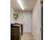 A compact laundry room featuring a black washer and dryer and storage shelves at 208 Lagoon Mist Ct, Oak Hill, FL 32759