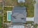 Aerial view showcases the home's pool, well-manicured landscaping, driveway and newly installed roof at 212 Due East St, New Smyrna Beach, FL 32169