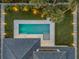 Aerial view of a private pool surrounded by lush landscaping, modern fence, and part of a luxurious home at 212 Due East St, New Smyrna Beach, FL 32169