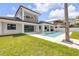A backyard with a pool, covered patio, and a manicured lawn at 212 Due East St, New Smyrna Beach, FL 32169