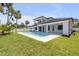 Beautiful backyard with a sparkling pool, lush green lawn and a modern home design at 212 Due East St, New Smyrna Beach, FL 32169