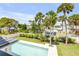 Landscaped backyard with new pool and fence features a lush garden and tall palms at 212 Due East St, New Smyrna Beach, FL 32169