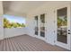 Outdoor balcony featuring wood floors and two sets of glass doors, creating a seamless indoor-outdoor living experience at 212 Due East St, New Smyrna Beach, FL 32169
