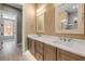 Elegant bathroom featuring double sinks with white countertops and stylish framed mirrors, complemented by light wood-look flooring at 212 Due East St, New Smyrna Beach, FL 32169