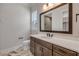 Bathroom featuring dark wood cabinets, neutral counter tops, decorative tile floor, and large mirror at 212 Due East St, New Smyrna Beach, FL 32169