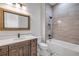Stylish bathroom with dark wood vanity, elegant fixtures, and tub-shower, offering a luxurious and functional space at 212 Due East St, New Smyrna Beach, FL 32169