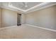 Cozy bedroom features neutral carpet, recessed lights, tray ceiling with fan, and easy access to en-suite bathroom at 212 Due East St, New Smyrna Beach, FL 32169