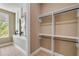 Well-organized walk-in closet with shelving units, providing ample storage space and natural light from the window at 212 Due East St, New Smyrna Beach, FL 32169