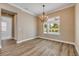Inviting dining room with hardwood floors, chandelier lighting, and a large window with a view of the outdoor pool at 212 Due East St, New Smyrna Beach, FL 32169
