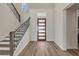 Bright entryway with a modern front door, staircase with wooden railings, and hardwood floors at 212 Due East St, New Smyrna Beach, FL 32169