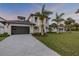 Beautiful exterior elevation with a large garage, front lawn, and palm trees at 212 Due East St, New Smyrna Beach, FL 32169
