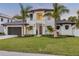 Stunning two-story home with lush landscaping, palm trees, and a modern garage door at 212 Due East St, New Smyrna Beach, FL 32169