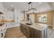 Elegant kitchen with an island sink, pendant lighting, stainless appliances, and a view of the outdoor pool at 212 Due East St, New Smyrna Beach, FL 32169