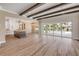 Spacious living room featuring hardwood floors, exposed beam ceilings, and glass sliding doors leading to the outdoor pool at 212 Due East St, New Smyrna Beach, FL 32169