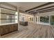 Bright open-concept living room with hardwood floors, exposed beam ceiling, and seamless access to the outdoor pool area at 212 Due East St, New Smyrna Beach, FL 32169