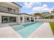 An inviting pool with travertine tile decking sits outside the rear of this modern home at 212 Due East St, New Smyrna Beach, FL 32169
