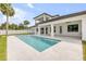 A newly installed pool with a travertine deck is set behind this modern home at 212 Due East St, New Smyrna Beach, FL 32169