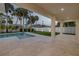 Inviting covered patio overlooks the pool and yard, perfect for outdoor dining and entertaining with lush greenery at 212 Due East St, New Smyrna Beach, FL 32169