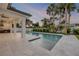 Beautiful pool and outdoor living space featuring stone patio, lush landscaping, and outdoor kitchen at 212 Due East St, New Smyrna Beach, FL 32169