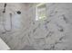 Modern bathroom with marble shower featuring a tiled bench and a handheld sprayer at 212 Due East St, New Smyrna Beach, FL 32169