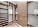 Walk-in closet with modern wood cabinetry, shelving, drawers, and hardwood floor at 212 Due East St, New Smyrna Beach, FL 32169