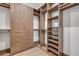 Large walk-in closet with modern wood cabinetry, shelving, and drawers at 212 Due East St, New Smyrna Beach, FL 32169