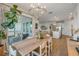 Bright dining area with a wooden table, a modern chandelier and sliding glass doors to the lanai at 220 Venetian Palms Blvd, New Smyrna Beach, FL 32168