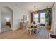 Bright dining room with wood floors, chandelier, and large windows offering scenic views at 220 Venetian Palms Blvd, New Smyrna Beach, FL 32168