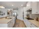 Open kitchen featuring stainless steel appliances, white cabinets, and a view into the living area at 220 Venetian Palms Blvd, New Smyrna Beach, FL 32168
