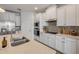 Well-lit kitchen featuring stainless steel appliances, white cabinetry, and quartz countertops at 220 Venetian Palms Blvd, New Smyrna Beach, FL 32168