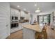 Modern kitchen with white cabinets, stainless steel appliances, a center island with seating, and a dining area at 220 Venetian Palms Blvd, New Smyrna Beach, FL 32168