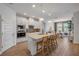 Modern kitchen features white cabinets, stainless steel appliances, a center island with seating, and an adjacent dining area at 220 Venetian Palms Blvd, New Smyrna Beach, FL 32168