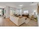 Bright living room with wood floors, comfortable seating, and large windows offering plenty of natural light at 220 Venetian Palms Blvd, New Smyrna Beach, FL 32168