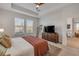 Comfortable main bedroom with tray ceilings, two windows, and a full dresser at 220 Venetian Palms Blvd, New Smyrna Beach, FL 32168