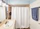 Bathroom with a shower featuring brown tiled walls and white shower curtains, along with towel racks at 2236 Davis Dr, New Smyrna Beach, FL 32168