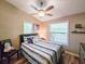 Cozy bedroom with a ceiling fan, windows providing natural light, and coastal-themed decor at 2236 Davis Dr, New Smyrna Beach, FL 32168