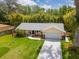 Charming home with a well-manicured lawn, mature trees, and a driveway leading to a garage at 2236 Davis Dr, New Smyrna Beach, FL 32168