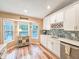 Bright kitchen features white cabinets, stainless steel appliances, and a window with a pool view at 2236 Davis Dr, New Smyrna Beach, FL 32168