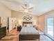 Cozy bedroom with neutral colors, wood floors, ceiling fan and access to the screened patio at 2236 Davis Dr, New Smyrna Beach, FL 32168
