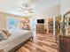Spacious main bedroom with wood floors, ceiling fan, and doors leading to the outside patio at 2236 Davis Dr, New Smyrna Beach, FL 32168
