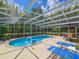 Inviting in-ground pool with a screened enclosure and outdoor lounge area at 2236 Davis Dr, New Smyrna Beach, FL 32168