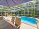 Beautiful in-ground pool with a screened enclosure and relaxing outdoor seating at 2236 Davis Dr, New Smyrna Beach, FL 32168