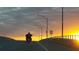 A motorcycle travels on a highway at sunset, speed limit sign is visible at 2236 Davis Dr, New Smyrna Beach, FL 32168
