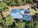 Stunning aerial view of house with screened pool, solar panels, and brick driveway, surrounded by lush trees at 2656 Old Smyrna Trl, New Smyrna Beach, FL 32168