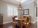 Cozy dining room with hardwood floors, a rustic chandelier, and seating for four at 2656 Old Smyrna Trl, New Smyrna Beach, FL 32168