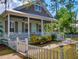 Inviting home exterior with a charming porch, well-maintained landscaping, and white picket fence at 2656 Old Smyrna Trl, New Smyrna Beach, FL 32168
